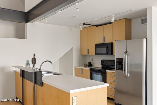 kitchen with visible vents, track lighting, light countertops, black appliances, and a sink