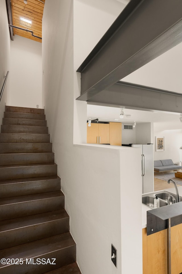 stairs with visible vents and wooden ceiling