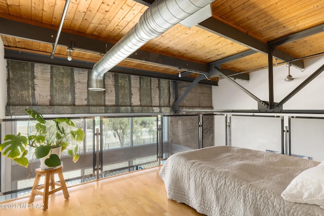 bedroom featuring beam ceiling, wood ceiling, and wood finished floors