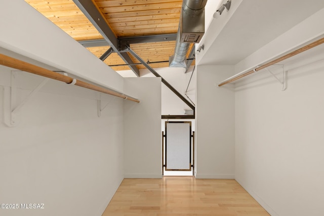 spacious closet with beam ceiling, wood finished floors, and visible vents