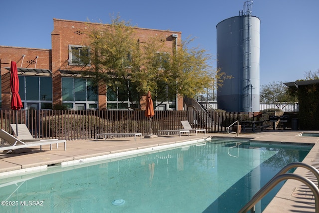 pool featuring a patio area and fence