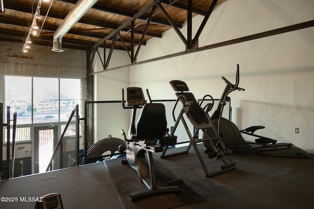 workout area featuring wooden ceiling and a towering ceiling