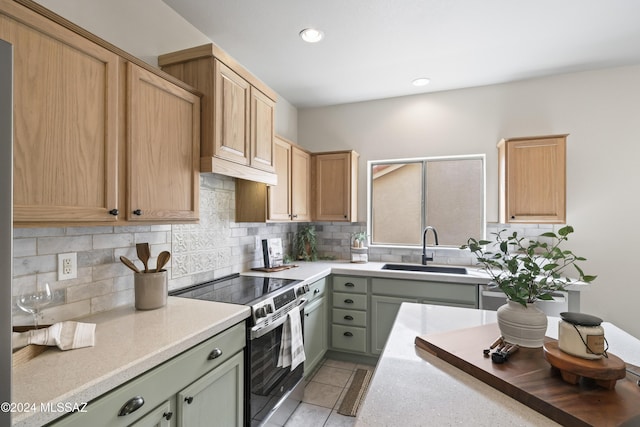 kitchen featuring decorative backsplash, stainless steel electric range, and a sink