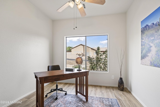 office area featuring baseboards, light wood-type flooring, and a ceiling fan