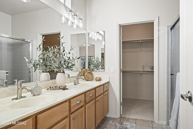 full bath featuring tile patterned flooring, a walk in closet, and a sink