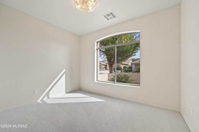 spare room featuring carpet flooring and visible vents