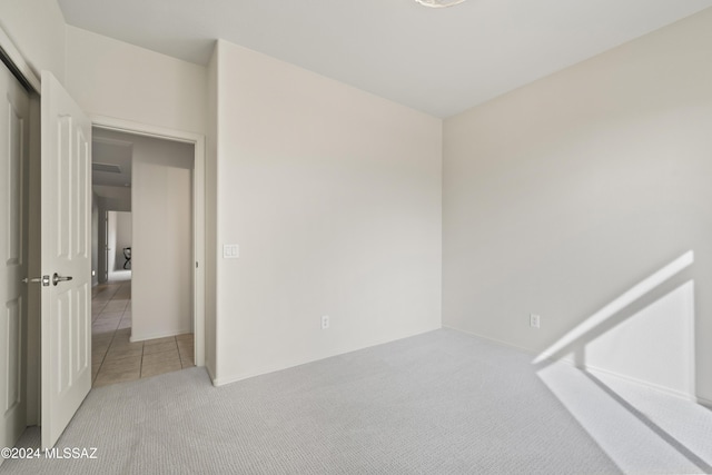 carpeted spare room with tile patterned floors