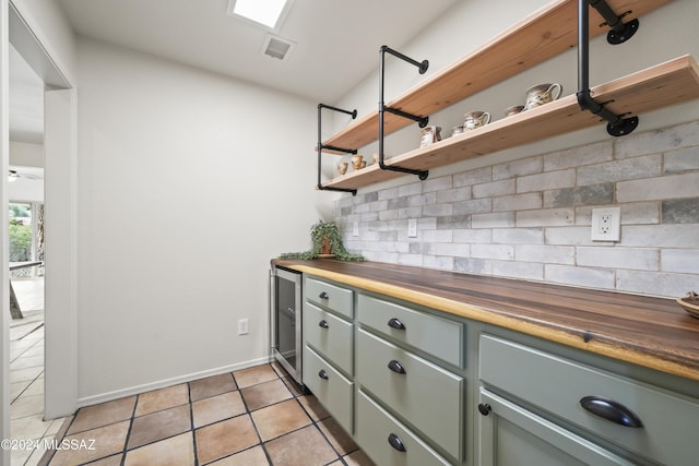 kitchen with tasteful backsplash, visible vents, butcher block counters, light tile patterned floors, and open shelves