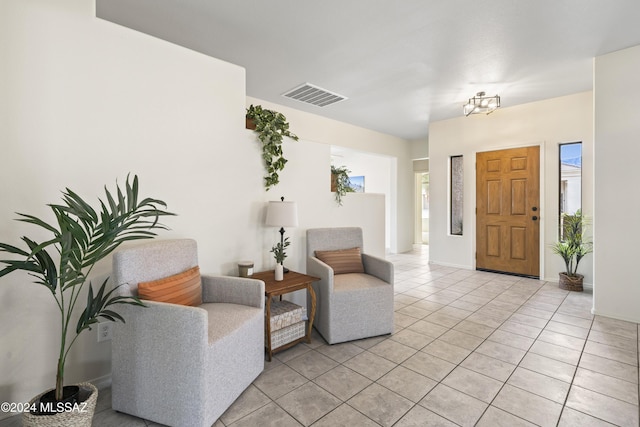 foyer with light tile patterned floors, visible vents, and baseboards