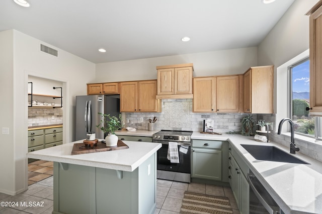 kitchen with visible vents, a sink, light countertops, appliances with stainless steel finishes, and a center island