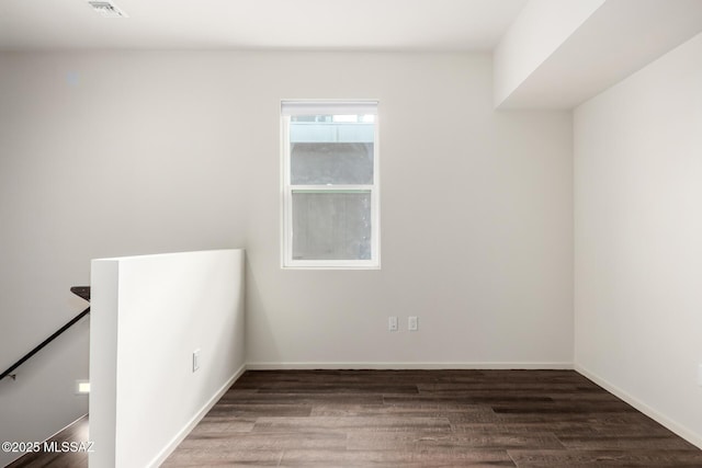 unfurnished room featuring visible vents, baseboards, and wood finished floors