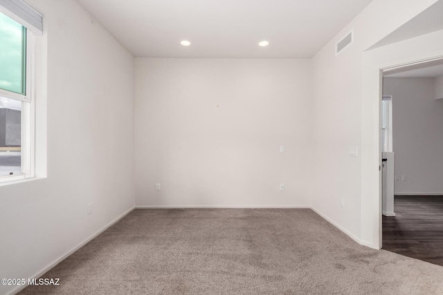 spare room with carpet flooring, plenty of natural light, recessed lighting, and visible vents