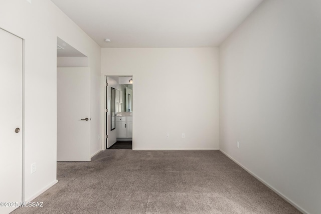 carpeted spare room featuring baseboards