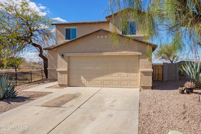 traditional-style house with stucco siding, driveway, an attached garage, and fence