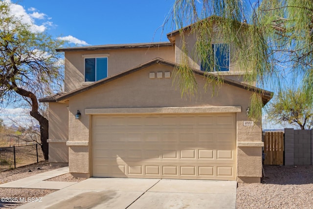 view of front of home featuring concrete driveway, fence, a garage, and stucco siding