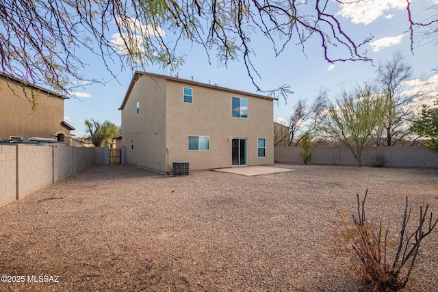 rear view of house featuring a patio area, cooling unit, a fenced backyard, and stucco siding