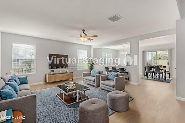 living area with baseboards, visible vents, carpet floors, and ceiling fan