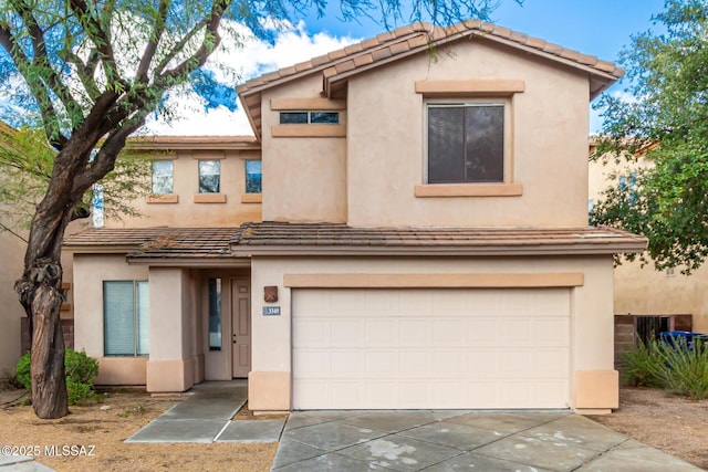 view of front of house featuring stucco siding, an attached garage, and driveway