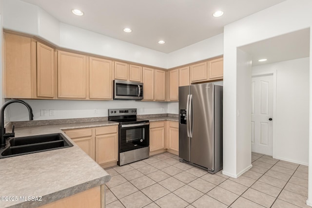 kitchen with light brown cabinets, recessed lighting, appliances with stainless steel finishes, light tile patterned flooring, and a sink