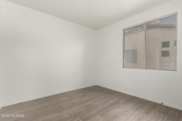 unfurnished room featuring wood finished floors and baseboards