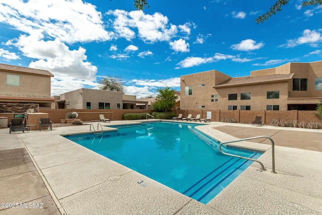 pool with a patio and fence