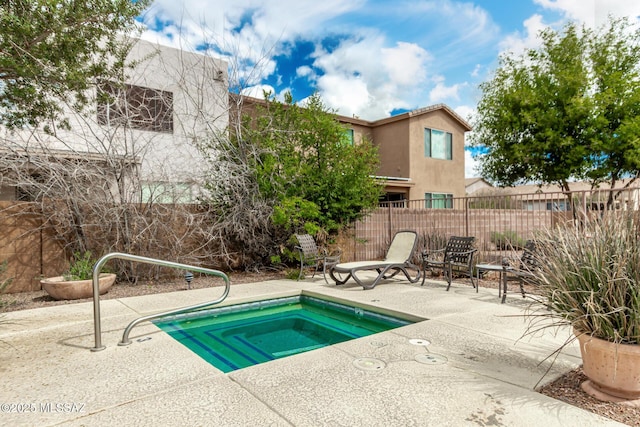 view of swimming pool featuring a patio area, an in ground hot tub, and fence