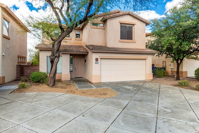 view of front of home featuring stucco siding, concrete driveway, an attached garage, and fence