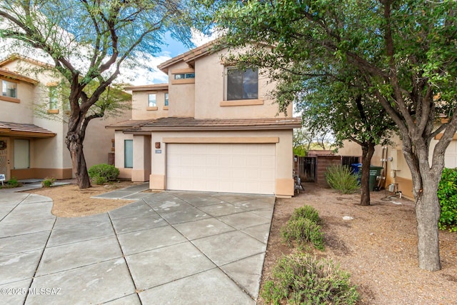 traditional-style house featuring stucco siding, concrete driveway, an attached garage, and a tile roof