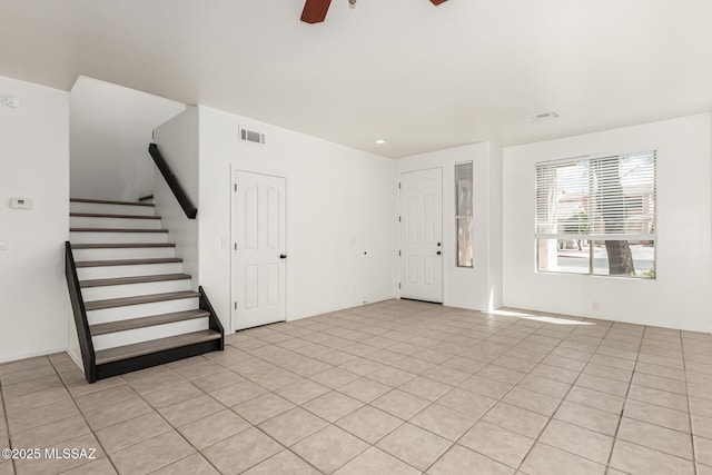 foyer with visible vents, stairs, and ceiling fan