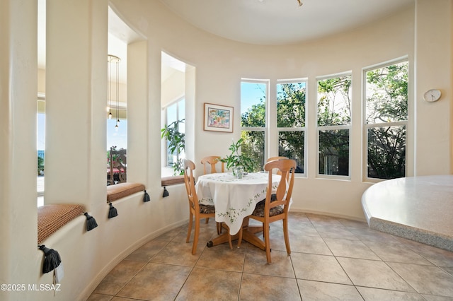 dining space featuring plenty of natural light, baseboards, and light tile patterned floors