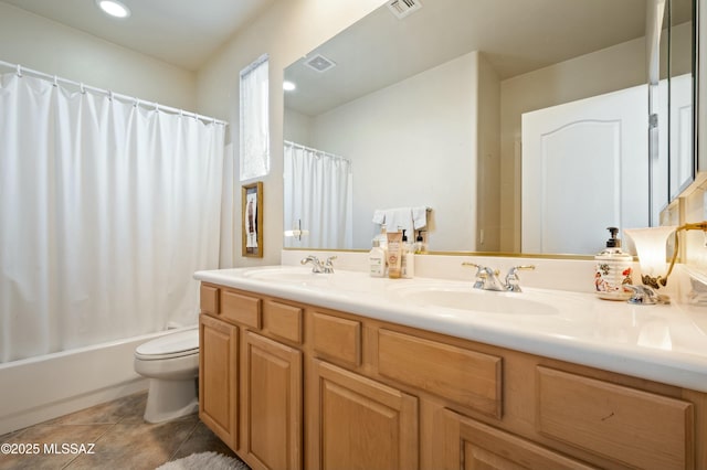 bathroom with tile patterned flooring, double vanity, toilet, and a sink