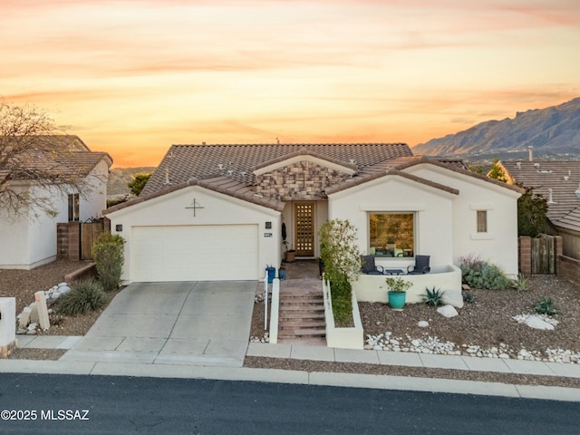 view of front of home with stucco siding, driveway, fence, a garage, and a tiled roof