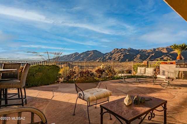 view of patio / terrace with a mountain view, an outdoor hangout area, and fence