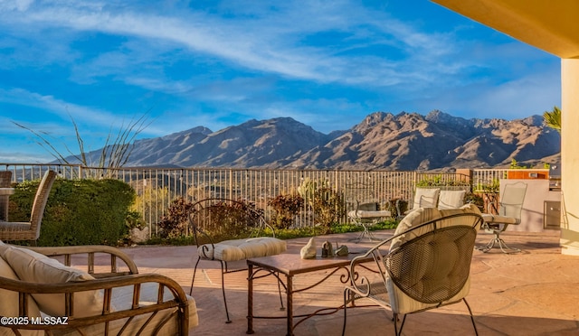 view of patio featuring a mountain view and fence