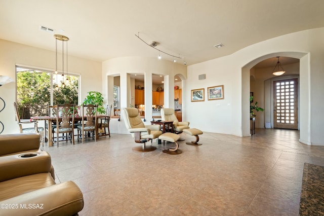 living room featuring arched walkways and visible vents