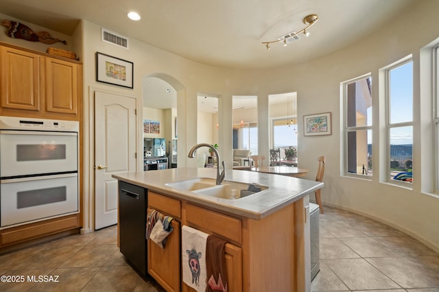 kitchen featuring light tile patterned flooring, a sink, light countertops, dishwasher, and double oven