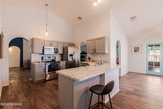 kitchen featuring arched walkways, a sink, visible vents, and stainless steel appliances