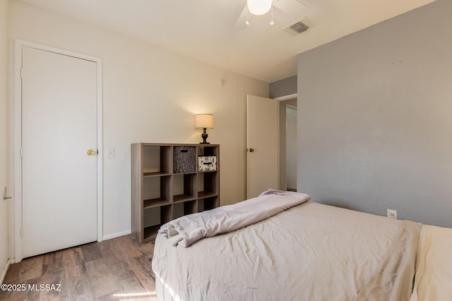 bedroom with visible vents, ceiling fan, and wood finished floors
