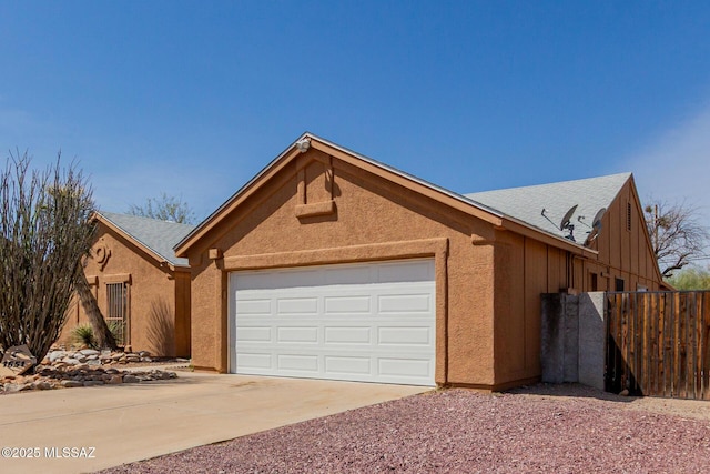 view of front of house featuring an attached garage, concrete driveway, and stucco siding