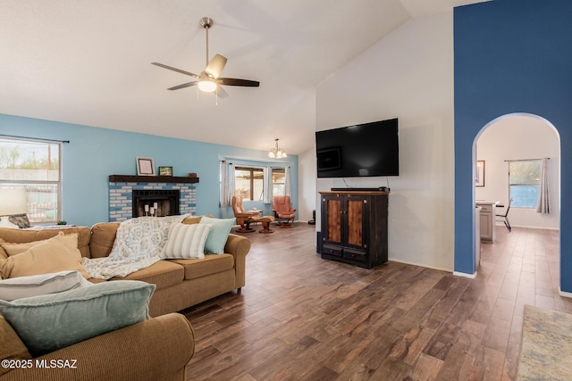 living room featuring ceiling fan, wood finished floors, high vaulted ceiling, and a brick fireplace