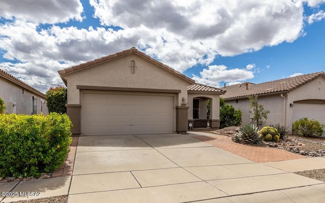 mediterranean / spanish home with stucco siding, a tile roof, and a garage