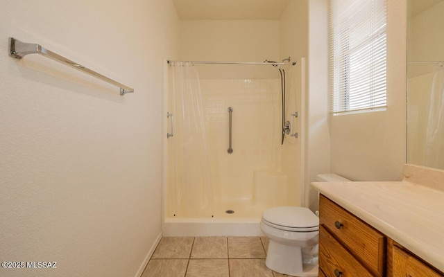 bathroom with tile patterned floors, vanity, toilet, and a shower