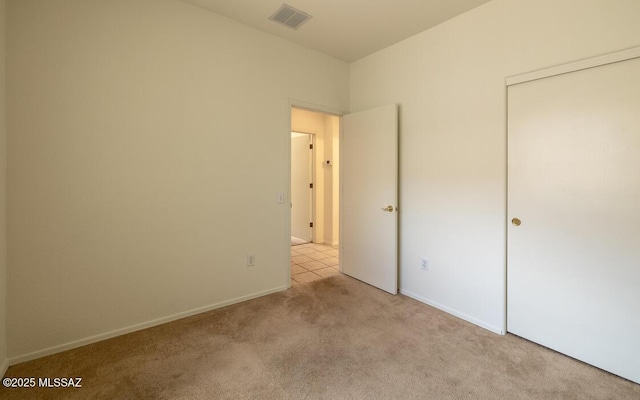 unfurnished bedroom featuring visible vents, baseboards, and carpet