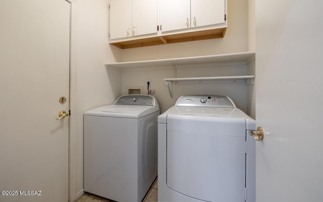 laundry room with washing machine and clothes dryer and cabinet space