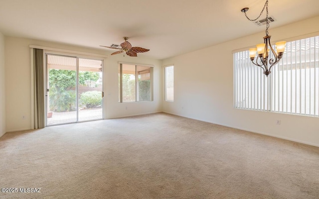 spare room featuring ceiling fan with notable chandelier, visible vents, and light carpet