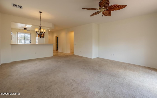 unfurnished room with visible vents, light carpet, and ceiling fan with notable chandelier