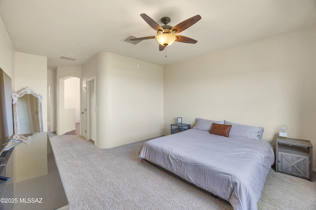 bedroom featuring arched walkways, visible vents, a ceiling fan, and carpet