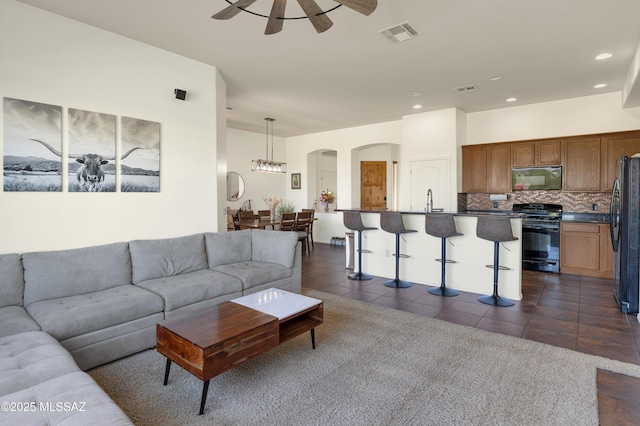 living room featuring a ceiling fan, dark tile patterned flooring, recessed lighting, and visible vents