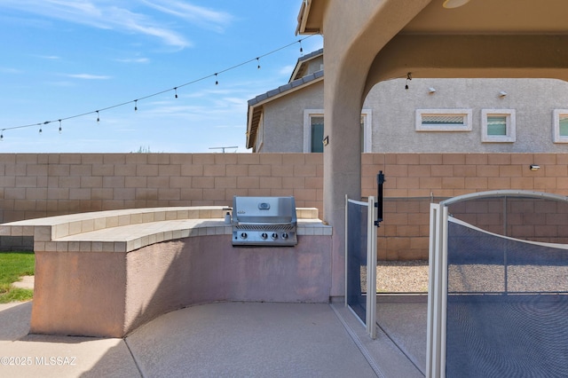 view of patio featuring exterior kitchen, fence, and grilling area