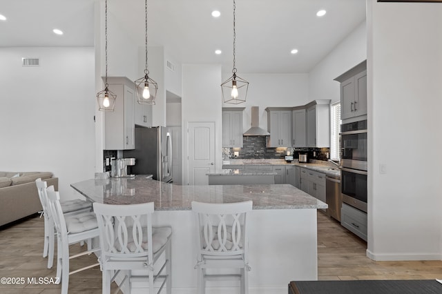 3337 E Wet Sand Pl, Vail, AZ 85641 - kitchen featuring stainless steel appliances, wall chimney range hood, a peninsula, gray cabinets, and tasteful backsplash